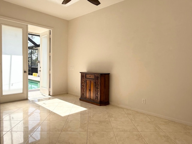 unfurnished room with light tile patterned floors, baseboards, and a ceiling fan