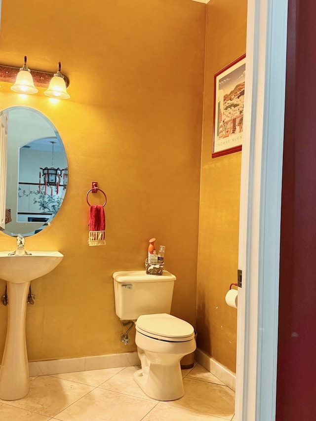 bathroom with toilet, baseboards, and tile patterned floors