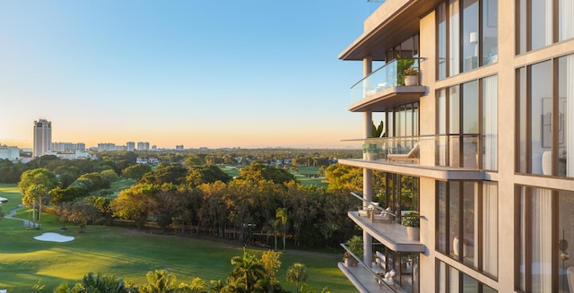 exterior space with golf course view and a lawn