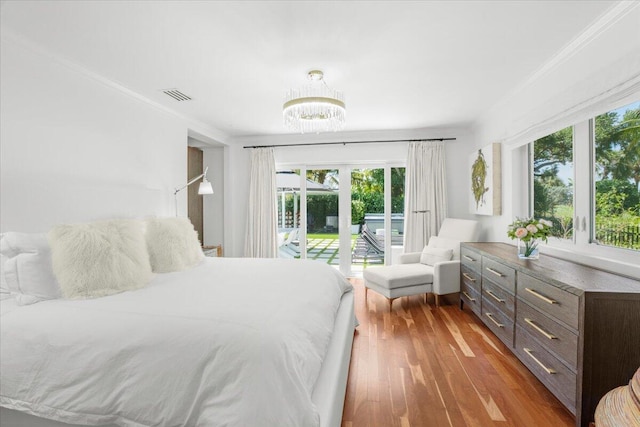 bedroom with multiple windows, visible vents, access to exterior, and a notable chandelier