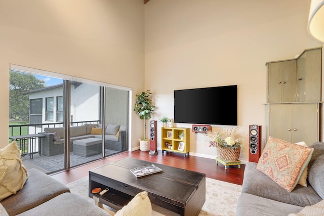 730 Greensward Ct Unit 203J, Delray Beach, FL 33445 - living room featuring a towering ceiling, wood finished floors, and baseboards