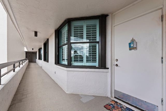 doorway to property featuring stucco siding and a balcony