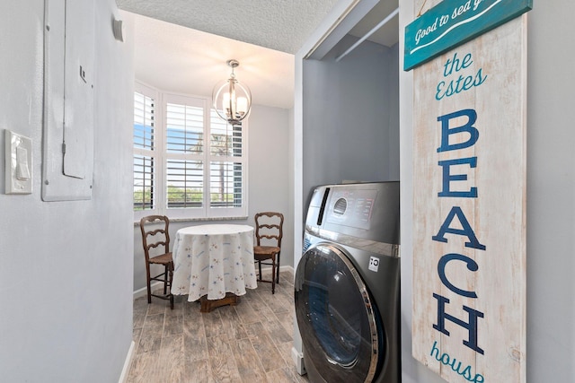 washroom featuring baseboards, washer / clothes dryer, an inviting chandelier, and wood finished floors