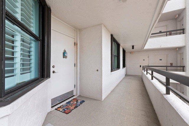 doorway to property with a balcony and stucco siding