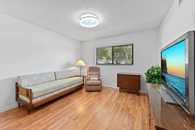15244 Lakes Of Delray Blvd Unit 203, Delray Beach, FL 33484 - sitting room featuring a textured ceiling, light wood finished floors, and baseboards