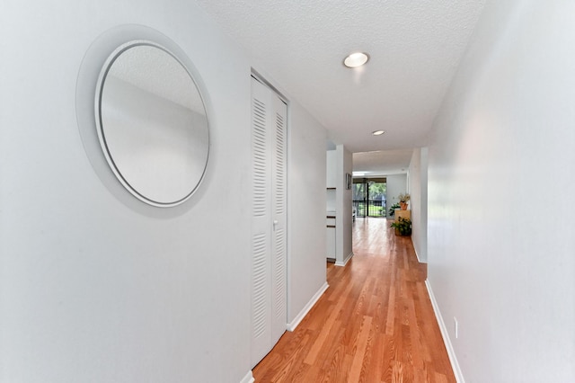 15244 Lakes Of Delray Blvd Unit 203, Delray Beach, FL 33484 - hallway featuring light wood-style floors, baseboards, recessed lighting, and a textured ceiling