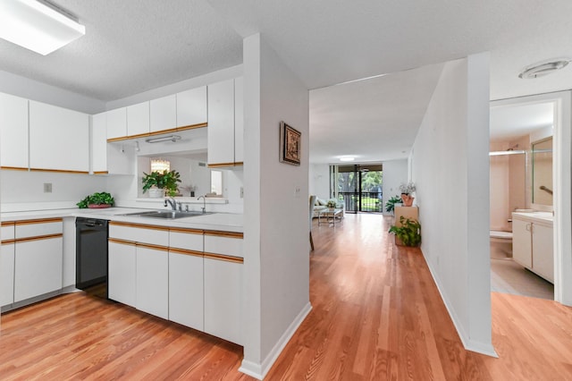 15244 Lakes Of Delray Blvd Unit 203, Delray Beach, FL 33484 - kitchen with a sink, light wood-style floors, light countertops, dishwasher, and white cabinetry