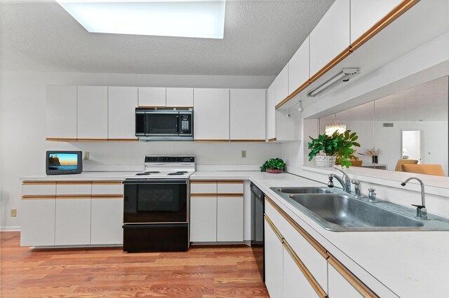 15244 Lakes Of Delray Blvd Unit 203, Delray Beach, FL 33484 - kitchen with stainless steel microwave, range with electric stovetop, a sink, light wood-style floors, and light countertops