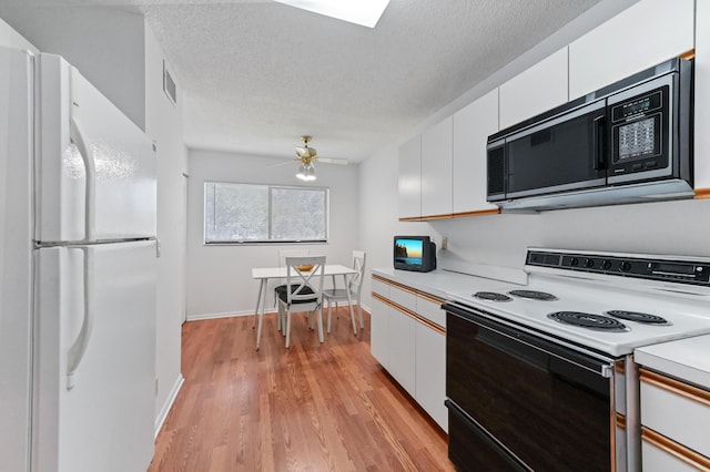 15244 Lakes Of Delray Blvd Unit 203, Delray Beach, FL 33484 - kitchen featuring electric range, freestanding refrigerator, stainless steel microwave, light countertops, and white cabinetry
