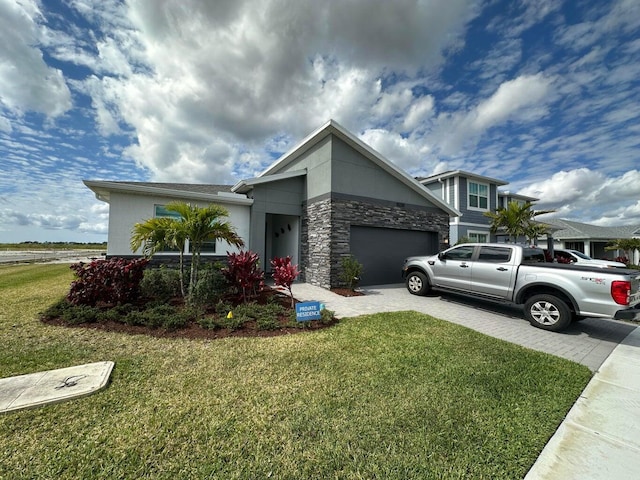 10230 SW Orana Dr, Port Saint Lucie, FL 34987 - view of front of house with driveway, a front yard, a garage, stone siding, and stucco siding