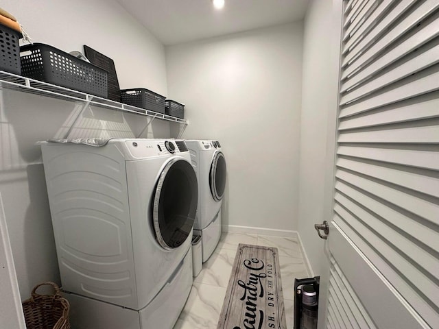 10230 SW Orana Dr, Port Saint Lucie, FL 34987 - washroom with light marble finish floors, washing machine and clothes dryer, and baseboards