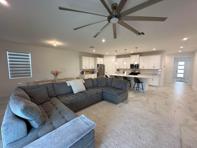 10230 SW Orana Dr, Port Saint Lucie, FL 34987 - living room with light marble finish flooring, recessed lighting, and a ceiling fan