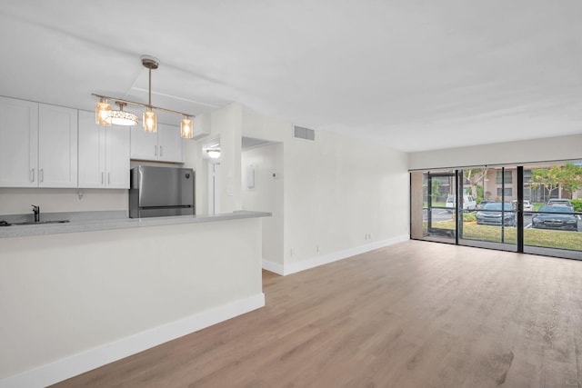 5821 Washington St Unit 21, Hollywood, FL 33023 - unfurnished living room featuring baseboards, light wood-type flooring, and a sink