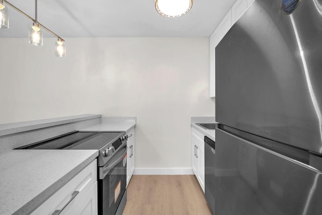 5821 Washington St Unit 21, Hollywood, FL 33023 - kitchen featuring appliances with stainless steel finishes, white cabinetry, light wood-style floors, light countertops, and hanging light fixtures