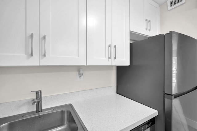 5821 Washington St Unit 21, Hollywood, FL 33023 - kitchen with freestanding refrigerator, a sink, white cabinets, and light countertops