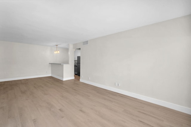 5821 Washington St Unit 21, Hollywood, FL 33023 - unfurnished living room featuring light wood-type flooring, baseboards, and a chandelier