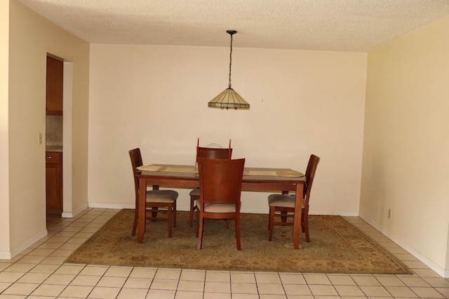 dining room with light tile patterned floors and a textured ceiling
