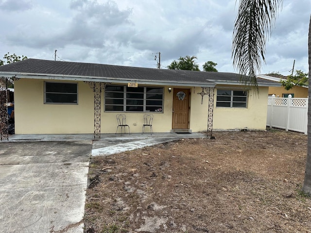 615 Garnett St, Lantana, FL 33462 - view of front of home featuring stucco siding, fence, and a porch