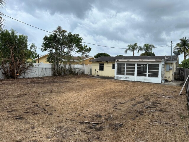 615 Garnett St, Lantana, FL 33462 - rear view of house featuring fence and a sunroom