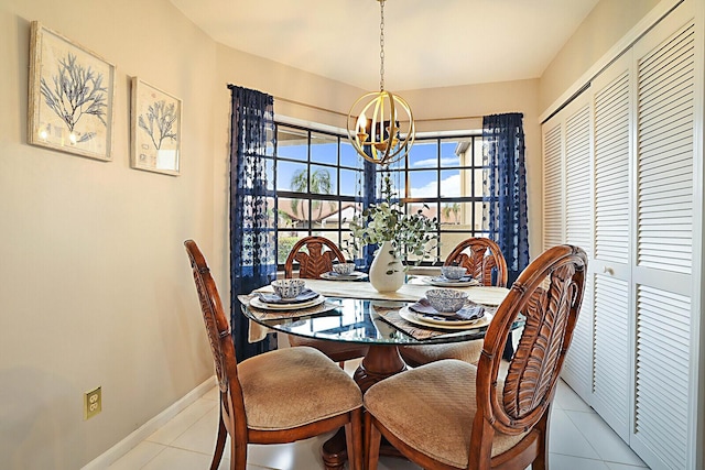 dining space with tile patterned flooring, a notable chandelier, and baseboards