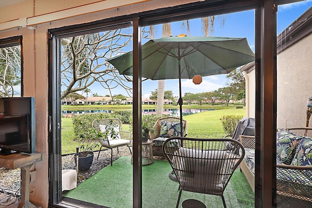 sunroom / solarium featuring a water view