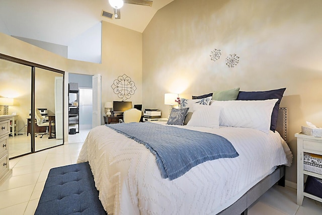 bedroom featuring light tile patterned floors, high vaulted ceiling, and a closet