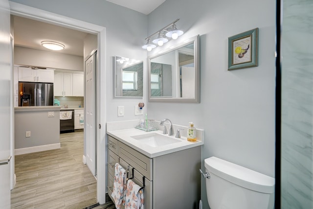 bathroom featuring vanity, toilet, and wood finished floors