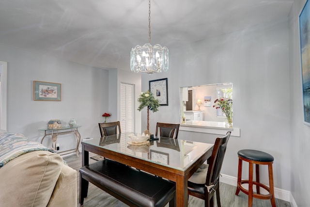 dining room with baseboards, an inviting chandelier, and wood finished floors
