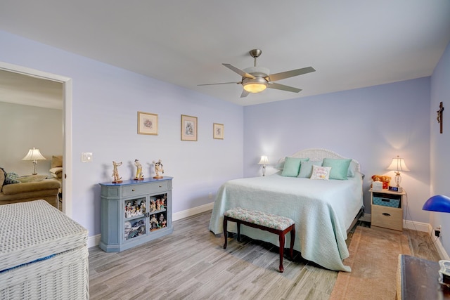 bedroom featuring wood finished floors, baseboards, and ceiling fan
