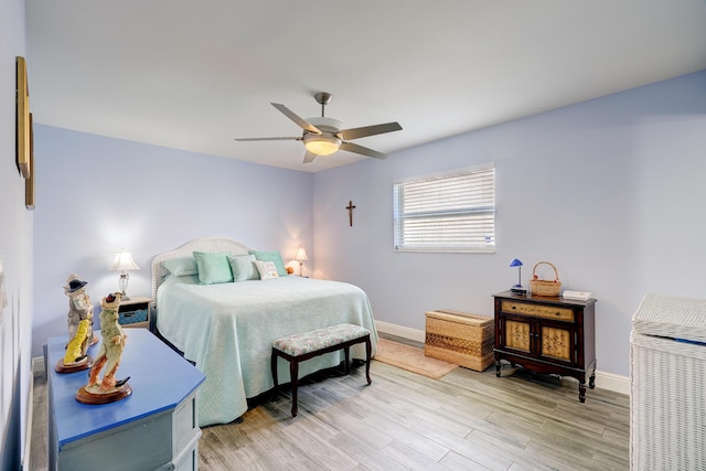 bedroom featuring baseboards, light wood-style floors, and a ceiling fan