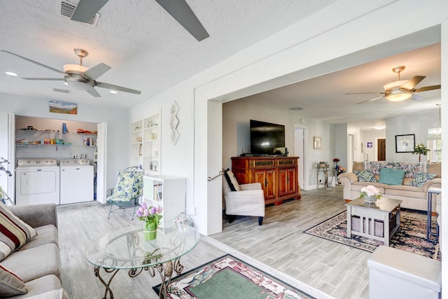 living area with a ceiling fan, light wood-style floors, and washer and clothes dryer