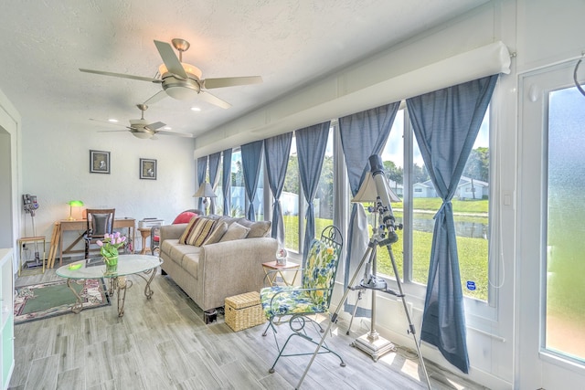 living area with a ceiling fan, recessed lighting, a textured ceiling, and wood finished floors
