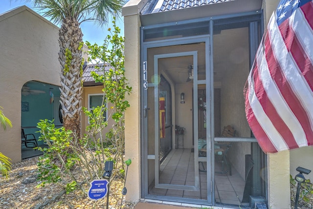 doorway to property featuring stucco siding