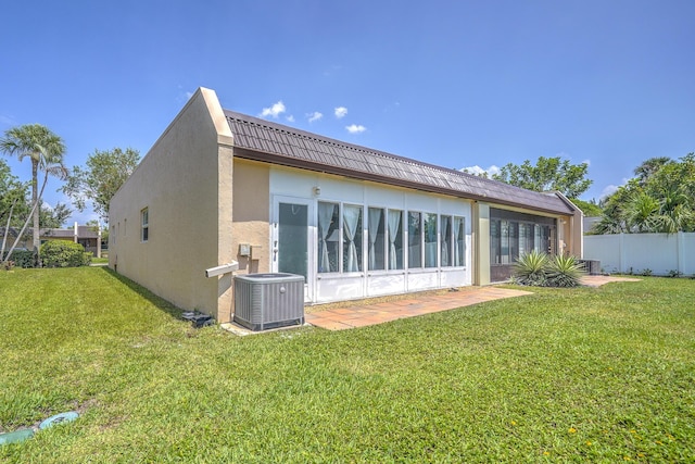 back of house with a lawn, cooling unit, stucco siding, and fence