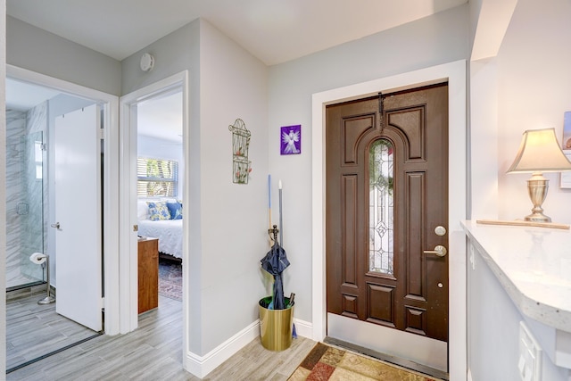 foyer featuring light wood finished floors and baseboards