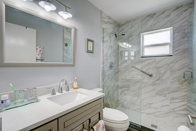 bathroom with a stall shower, vanity, and toilet