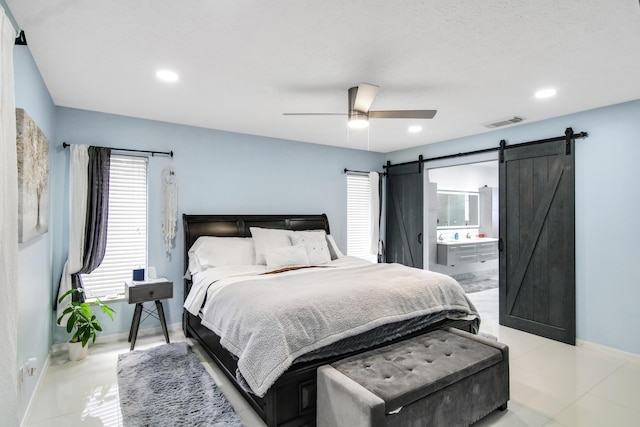 bedroom featuring a ceiling fan, visible vents, a barn door, baseboards, and recessed lighting