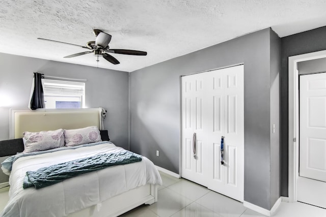bedroom featuring baseboards, a closet, ceiling fan, and a textured ceiling