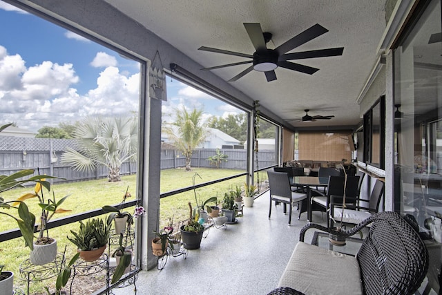 sunroom / solarium with outdoor dining area and a ceiling fan