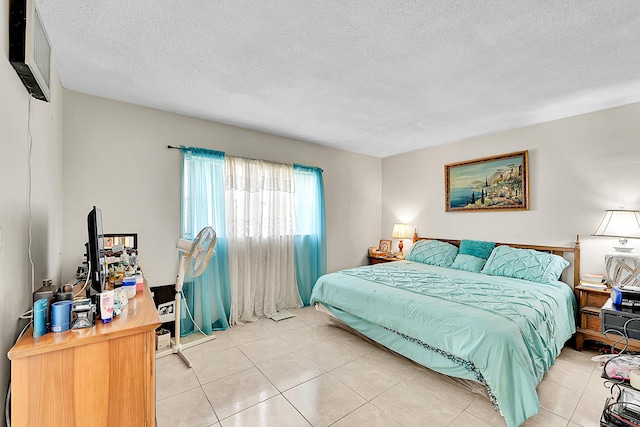 bedroom featuring light tile patterned flooring and a textured ceiling