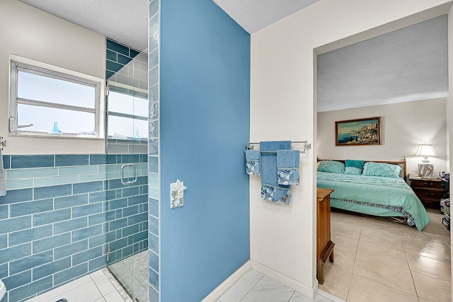 bathroom with a shower stall, connected bathroom, baseboards, a textured ceiling, and tile patterned floors