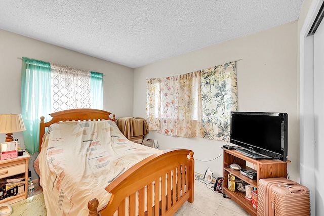 bedroom featuring a textured ceiling, tile patterned floors, and a closet
