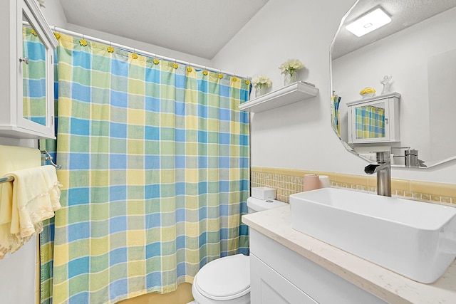 full bathroom featuring tile walls, toilet, vanity, a wainscoted wall, and a shower with curtain
