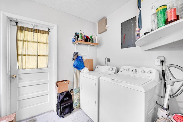 laundry area featuring electric panel, washing machine and dryer, and a textured ceiling