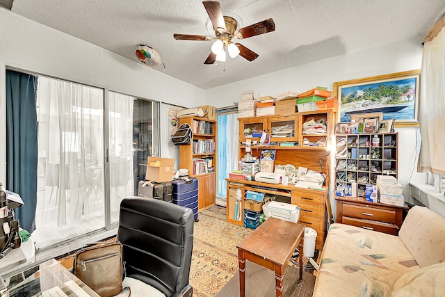 office with ceiling fan and a textured ceiling