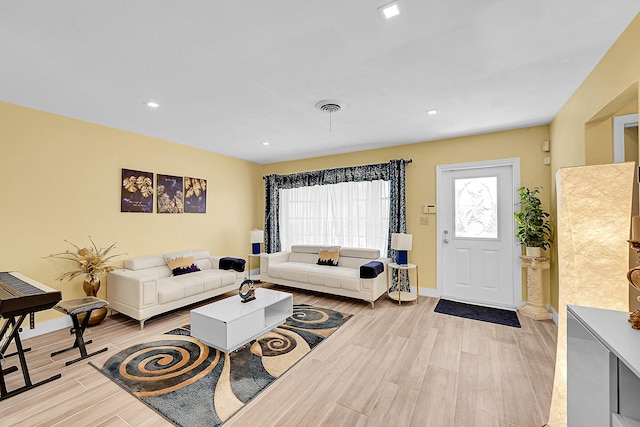 living room with light wood-type flooring, baseboards, and recessed lighting