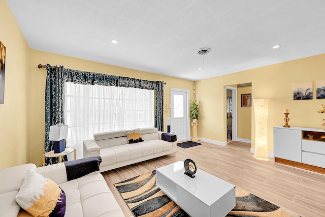 living room with light wood-style floors, baseboards, and recessed lighting