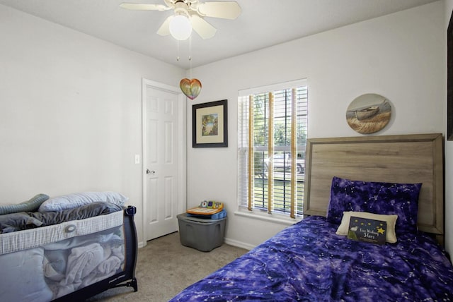 carpeted bedroom with multiple windows, baseboards, and a ceiling fan