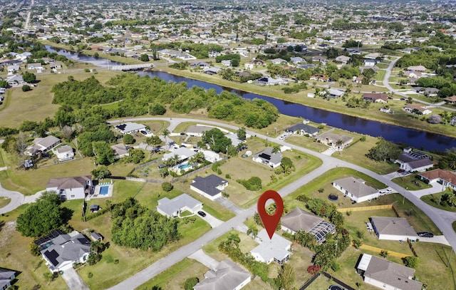 aerial view of property and surrounding area with a large body of water and nearby suburban area