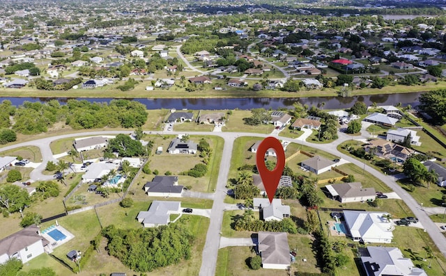 aerial view of property and surrounding area with nearby suburban area and a large body of water